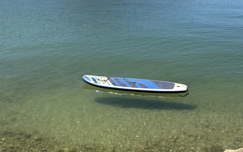 A paddleboard on the clear water of Whiskeytown Lake