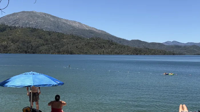 A beach umbrella and open water at full pool on Whiskeytown Lake