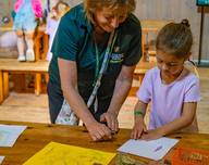 An educator and a young child at a craft table, from the Little Explorers event listing